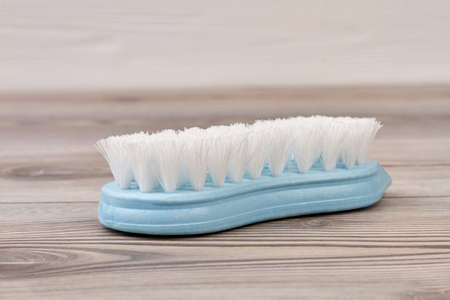 Blue plastic brush on wooden background. Blue scrubbing brush. Washing brush on wood.の写真素材