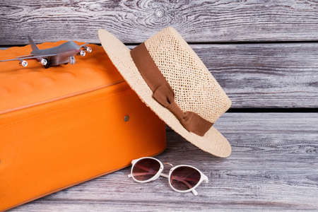 Women straw hat and sunglasses. Travel and resort concept. Toy tiny airplane.の写真素材