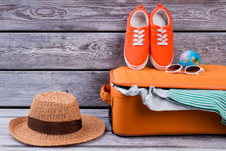 Female clothes and suitcase for vacation. Womens items and summer clothes for resort, ready for travel.の写真素材