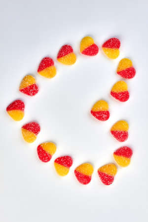 Heart made from colorful candies. Heart from sugary heart shaped candies on white background with...