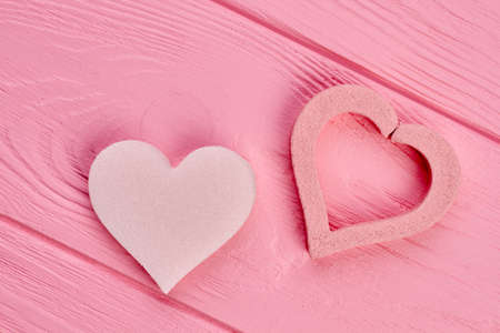 Two heart shapes on pink wood. Heart pumice stones on colorful wooden background. Valentines holiday design.の写真素材