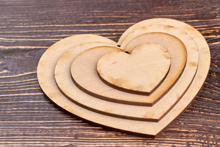Valentines Day background with wooden hearts. Hearts made of wood on textured wooden background. Festive gift card.の写真素材