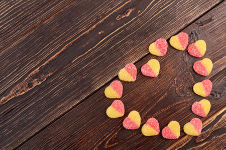 Heart from candies and copy space. Shape of heart from sugary sweets on wooden textured background and space for text.の写真素材