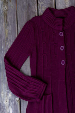 Female trendy knitted cardigan. Feminine high quality apparel on wooden background. New collection...