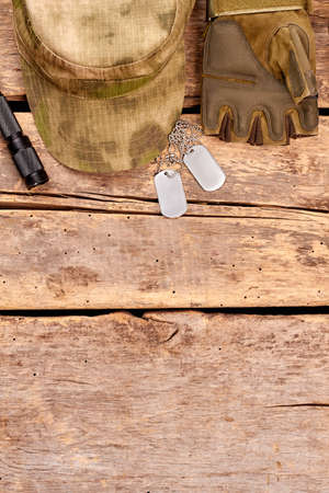Essentials of military soldier items. Top view, flat lay. Wooden desk surface background with copyspace.の写真素材