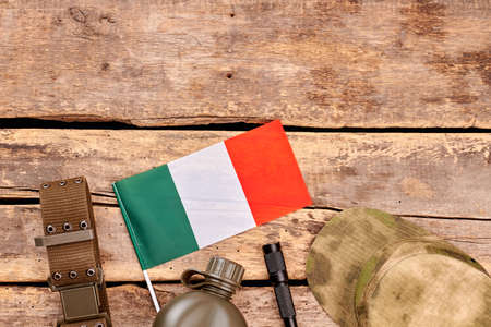 Accessories of italian army soldier. Flat lay, top view. Wooden desk table with copyspace.の写真素材