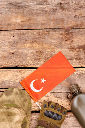Clothes and accessories of turkish soldier. Flag of Turkey and military essentials. Wooden desk table with copyspace.の写真素材