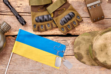 Ukrainian army soldier items arrangement. Top view, flat lay. Wooden background.の写真素材