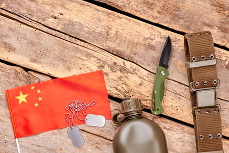 Chineese flag and military travel items. Top view, flat lay. Wooden background.