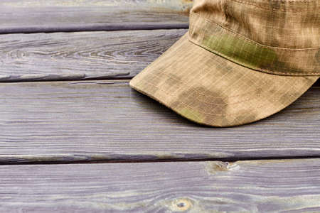 Military cap close up. Wooden desk surface background.