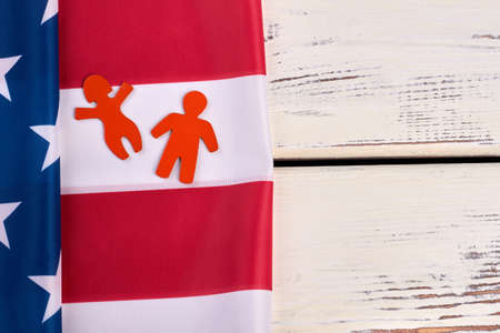 American flag on wooden background, copy space. Flag of America and red figures of man and woman. People and independence.の写真素材