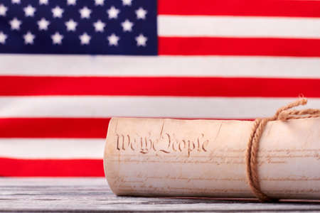 Close up Constitution of US on USA flag background. Declaration of Independence of the United States of America with american flag in the background.の写真素材