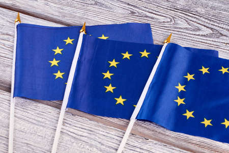Three cocktail flags of Europe. Set of mini flags of Europe on old wooden background close up.