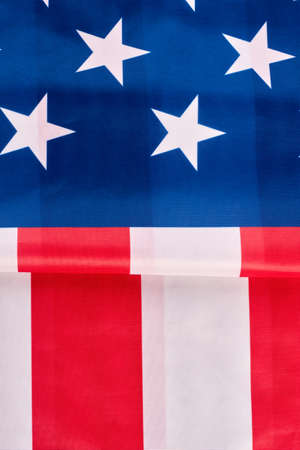 USA national flag background. Close up folded satin flag of United States of America, vertical image. Stars and stripes flag. Idea for banner. Happy fourth of July.の写真素材