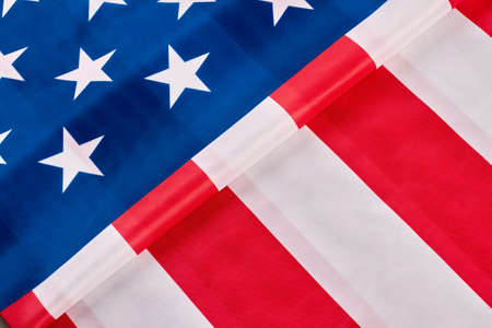 American flag background. Close up folded satin flag of the USA. Happy Independence Day. Idea for banner.の写真素材