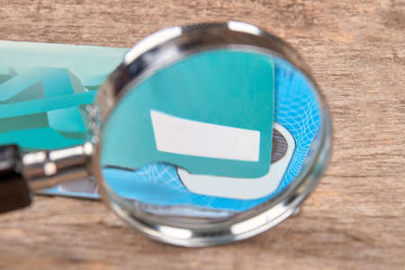 Cards and magnifying glass. Close up. Wooden desk background.の写真素材