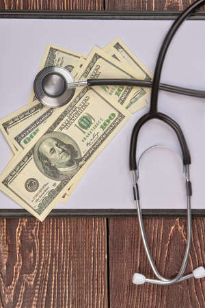 Stethoscope, hundreds of dollars and clipboard. Top view, flat lay.の写真素材