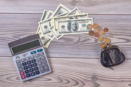 Calculator, dollars and coins with purse. Counting money concept. Flat lay, top view.の写真素材