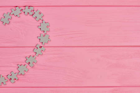 Heart from puzzles, cropped image. Cardboard puzzles formed shape of heart, copy space.