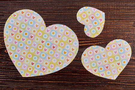 Three paper hearts on wooden background. Valentines holiday background. Paper hearts for banner....