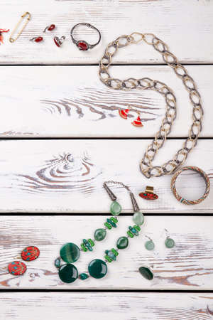 Vertical view jewellery necklaces and rings. Golden safety pin.