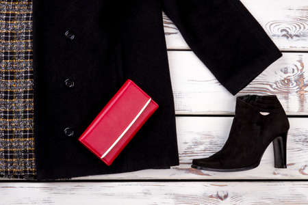 Close up stylish winter women clothes. Black suede heel boot and cashmere coat. Bright beige white...