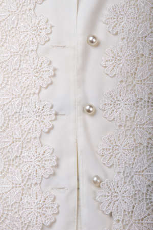 Close up shiny buttons on white women shirt. Fancy decorated shirt, vertical picture.