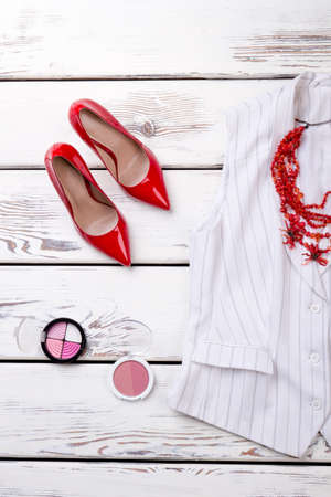 Red high heel shoes and cosmetic powder for make up. Vertical cropped view. Bright image.の写真素材
