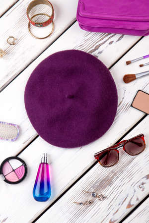 Collection of cosmetic accessories. Purple violet beret hat, spectacles and perfume.の写真素材