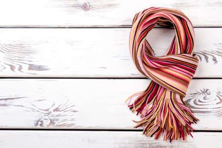Twisted stripe scarf. White wooden desks surface background.の写真素材
