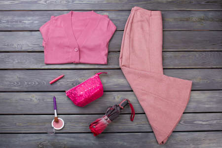 Set of pink winter clothing and accessories. Flat lay, woman necessities. Wooden desk surface background.の写真素材