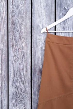 Top view dark wooden desk and hanger with clothes. Close up. Grey desk surface background.の写真素材