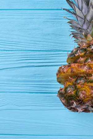 Fresh exotic ananas and copy space. Ripe organic pineapple on textured wooden background. Summer refreshment concept.の写真素材