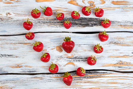 Fresh ripe strawberries in heart shape. Fresh healthy berries forming heart shape on wooden surface. Happy Valentines holiday.の写真素材