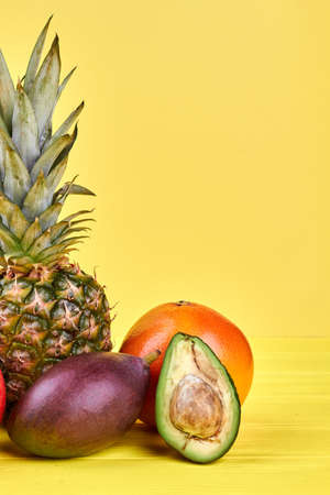 Group of ripe tropical fruits. Whole tropical fruits and half of avocado. Delicious exotic food.の写真素材