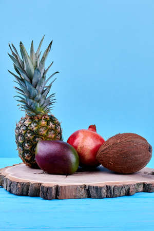 Assortment of exotic fruits on round wood. Composition of ripe tropical fruits. Healthy eating and...