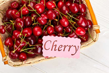 Basket of red organic cherries. Ripe summer berries in basket. Sweet seasonal fruit.の写真素材
