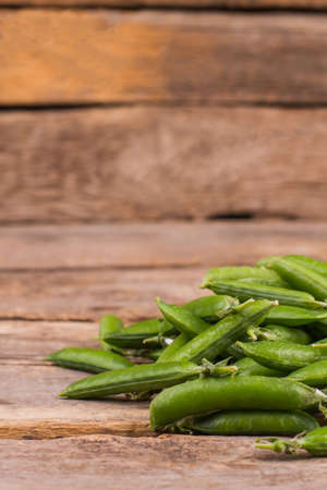 Big pile of green peas. Ripe rustic wooden table background.の写真素材
