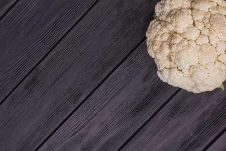 Fresh ripe cauliflower. Free space for text, copyspace. Dark wooden table surface.の写真素材
