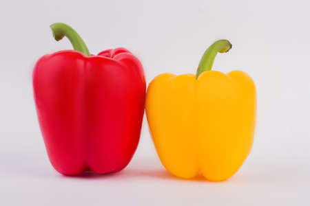 Two paprika vegetables. Red and yellow bell peppers over white background.の写真素材