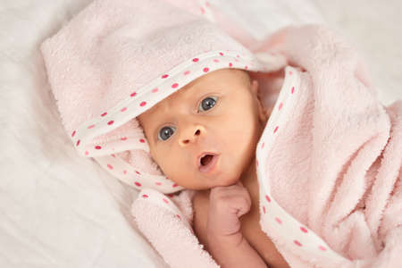 Close up portrait newborn baby face. Baby newborn covered on pink woolen blanket.