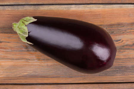 Ripe fresh eggplant close up. Healthy fresh eggplant shot on wooden background.の写真素材