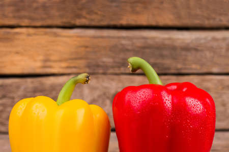 Two bell peppers on wooden background. Close up. Yellow and red.の写真素材