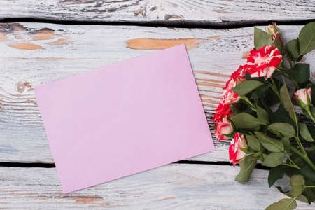 Boquet of beautiful flowers and empty paper. Free space for text. White wood background.の写真素材