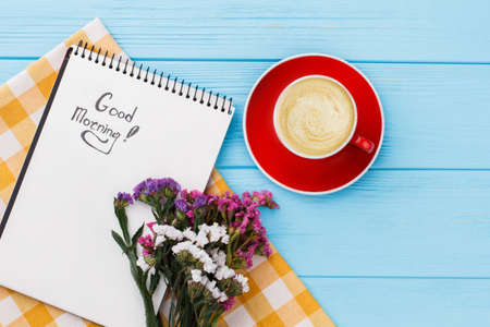 Good morning concept, cop of coffee and flowers. Pleasant surprise for girlfriend. Blue wooden table background.の写真素材