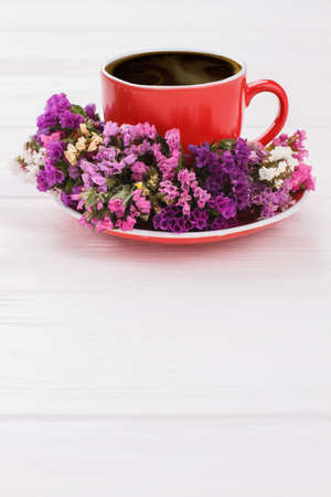 Dried flowers and red coffee cup. Copyspace, free space for text. White wooden surface background.の写真素材
