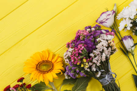 Variety of flowers on wood. Dahlia, sunflower, dried limonium statice, lisianthus and chamomile...