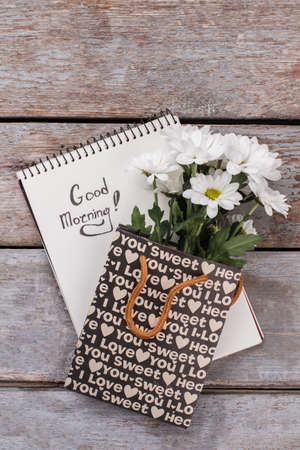Notepad with good morning wish and flowers. Top view. Copyspace, free space for text.の写真素材