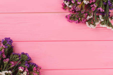 Two bouquets of statice flowers and copyspace. Pink wooden background.の写真素材