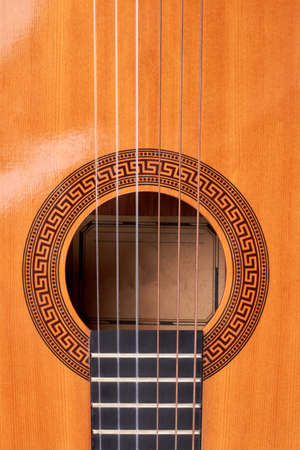 Ukulele guitar close up. Detail of yellow acoustic guitar, vertical image. Vintage musical guitar...